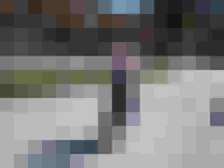 Kind auf dem Fahrrad mit Reflexschärpe fährt eine Straße entlang im Freien.