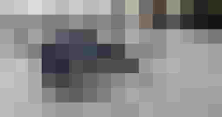 Schwarzes E-Lastenrad mit braunen Details auf einer Stadtstraße, umgeben von anderen Fahrrädern.