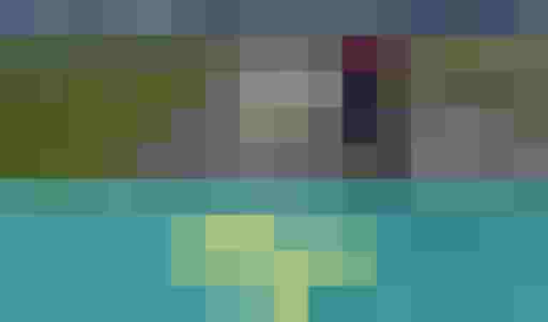 Radreisende mit Gepäck auf einer Landstraße, umgeben von grüner Landschaft und Bergen.