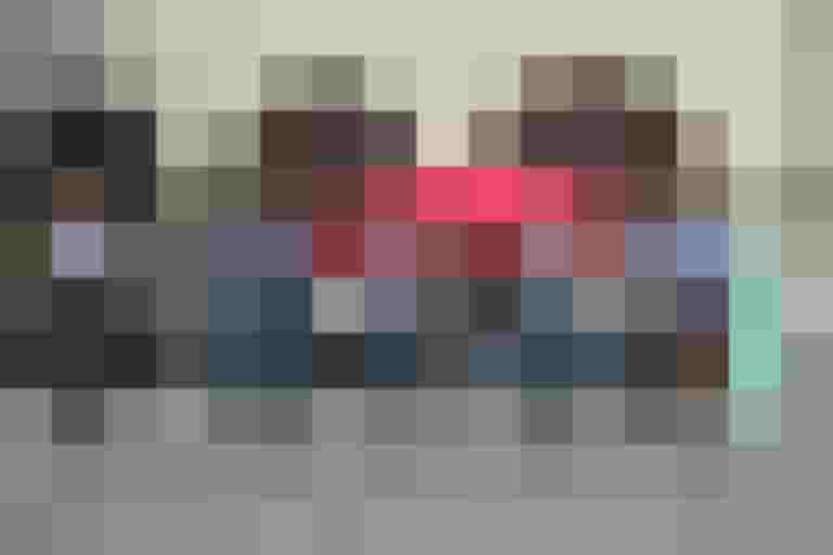 Fünf Radfahrer fahren lächelnd auf einem Platz vor einem Zelt.