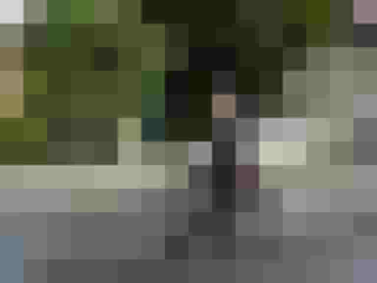 Mann im Zylinder fährt auf historischem Fahrrad in urbaner Umgebung.