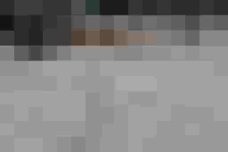 Fahrräder stehen auf taktilen Blindenleitsystemen, Laub auf dem Boden, städtische Umgebung.