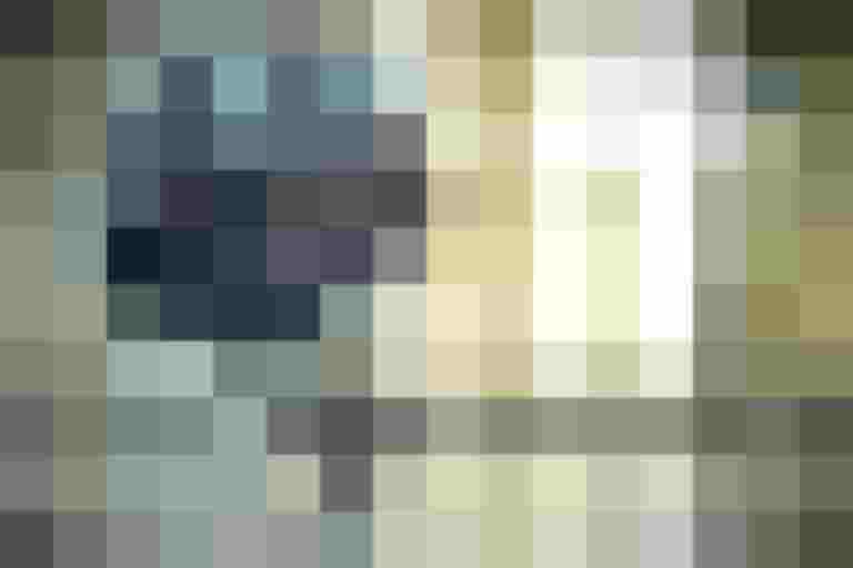 Fahrradhelm mit visier auf einem durchsichtigen Ständer vor hellem Hintergrund.