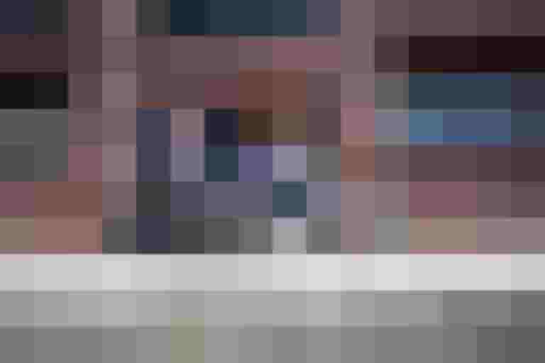 Eltern und Kind radeln auf dem Gehsteig vor einem modernen Gebäude in der Stadt.