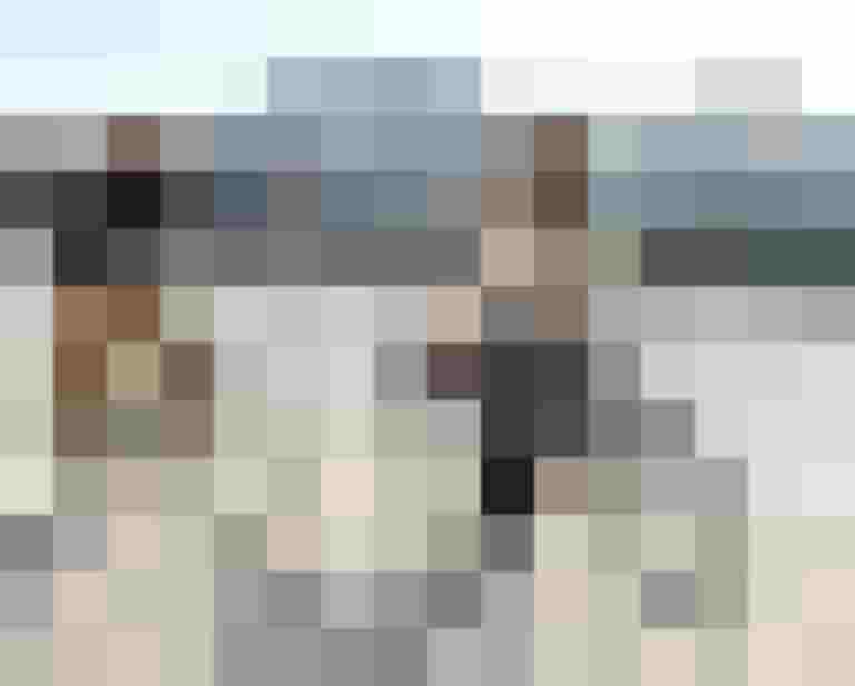 Frau und Mann radeln entlang der Salzach, im Hintergrund die Altstadt von Salzburg.