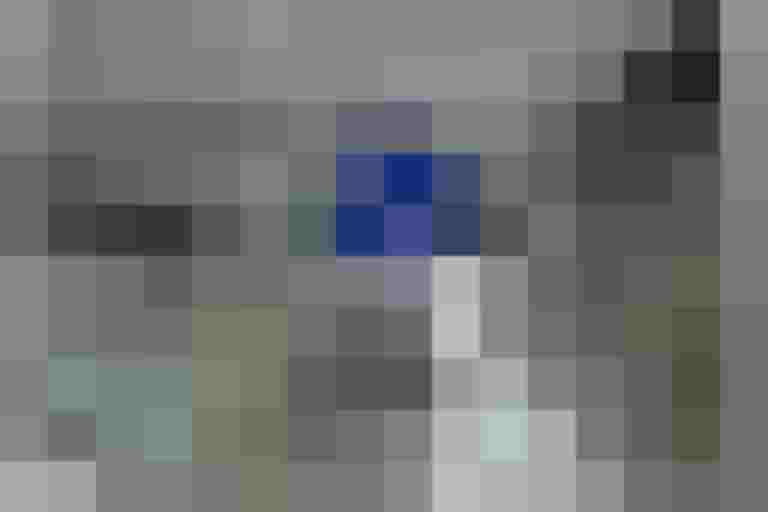 Fahrradparkplatz mit Schildern, moderne Architektur und stapelbare Fahrradständer.