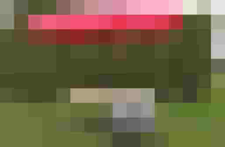 Fahrradanhänger mit rotem Sonnenschirm und Tisch für Veranstaltungen in Salzburg.