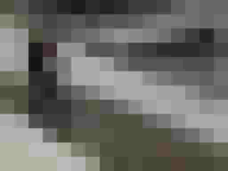 Radfahrer mit Rucksack fährt auf snowy Weg entlang einem Gewässer. Winterliche Bedingungen.