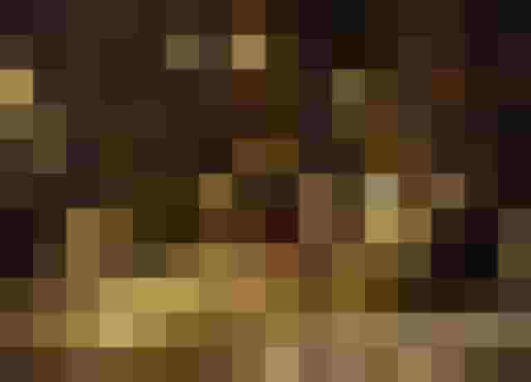 Radfahrer fährt nachts durch eine verschneite Straße, beleuchtet von Straßenlaternen.