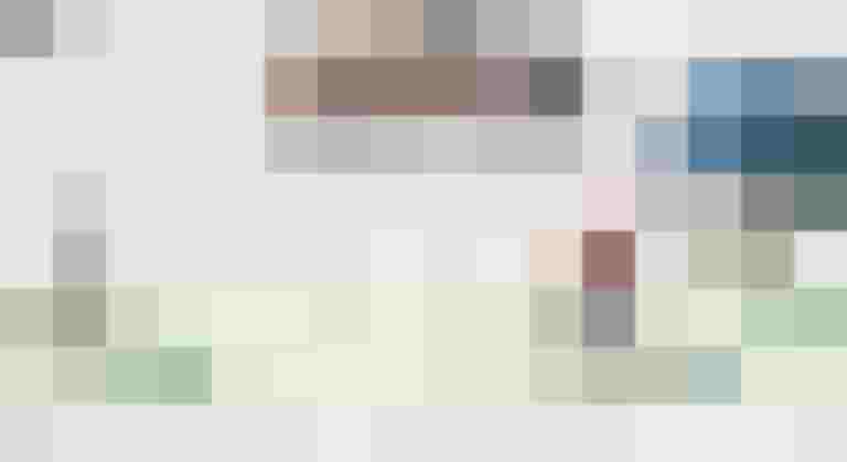 Radfahrer auf einer grünen Radspur, vorbeifahrende Autos in einer urbanen Umgebung.