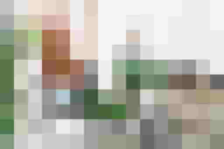 Mann lädt grüne Gemüsekisten auf ein weißes Lastenrad