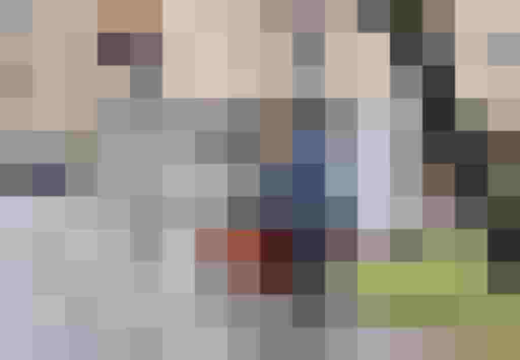 Person mit dreirädrigem Lastenrad an roter Ampel auf nasser Straße