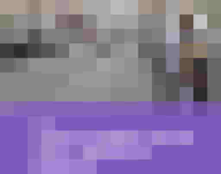 Kind mit Schulrucksack steht neben geparkten Autos auf einer städtischen Straße, herannahender Verkehr im Blick