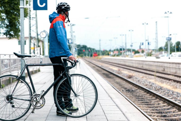 Person mit Fahrrad am Bahnsteig, bereit für die kostenfreie Fahrradmitnahme in Salzburg.