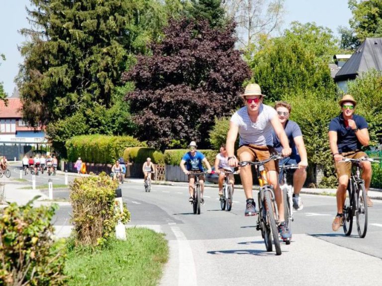 Radfahrende Gruppen genießen den motorfreien Tag am Obertrumersee im sonnigen Sommer.