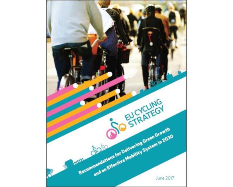 Radfahrer auf einer Straße mit EU Cycling Strategy Dokument im Vordergrund.