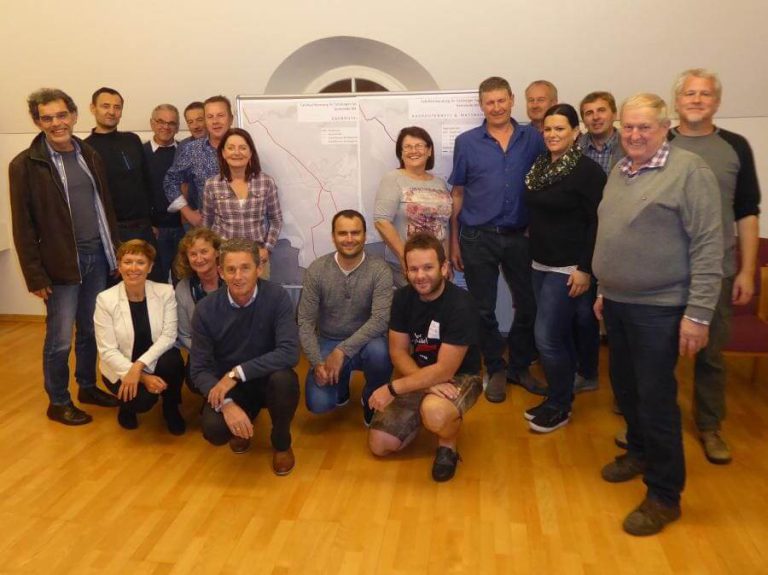 Gruppenfoto der Teilnehmer der Fahrradberatung in Anthering vor einem Plan.