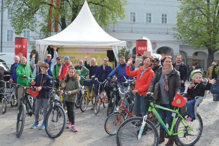 Gruppierung von Radfahrern in Salzburg, die für den Fotowettbewerb posieren.