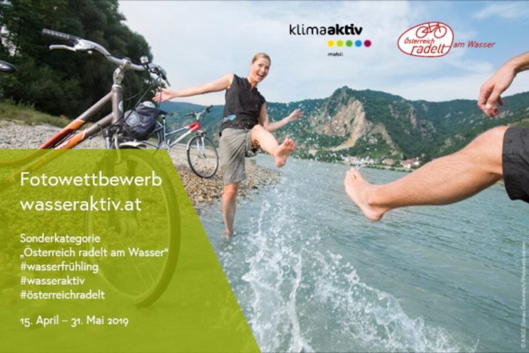 Frau planscht am Wasser, Fahrräder im Hintergrund, Fotowettbewerb „Österreich radelt am Wasser“.