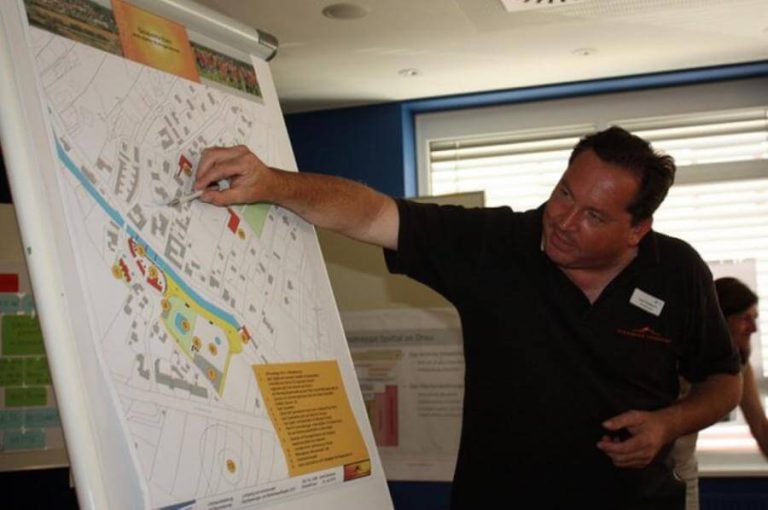 Ein Mann erläutert eine Karte zur kommunalen Raumplanung und Bodenschutz.