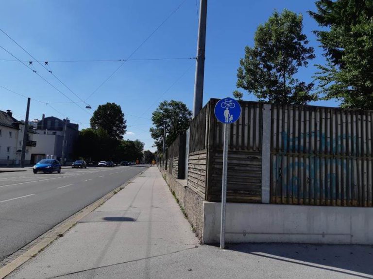 Geh- und Radweg an der Alpenstraße mit Verkehrsschild für Radfahrer in Salzburg.