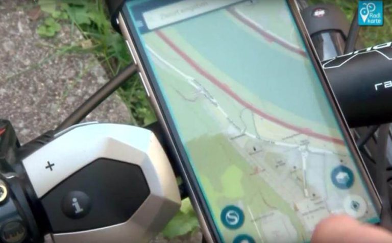 Smartphone mit Radlkarte-App auf einem Fahrradlenker zur Navigation.
