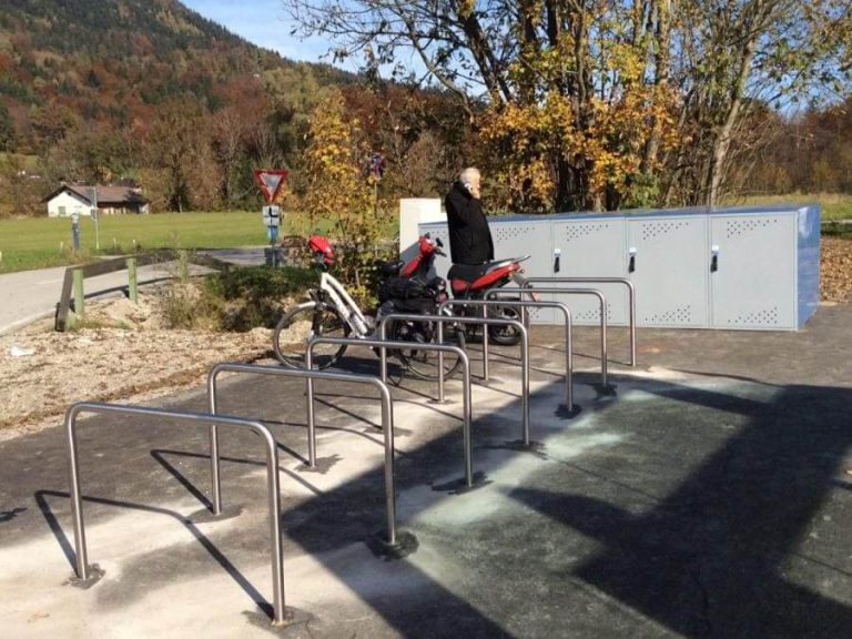 Neue Radboxen in Koppl bieten sicheren Abstellplatz für Fahrräder, im Hintergrund ein Radweg.