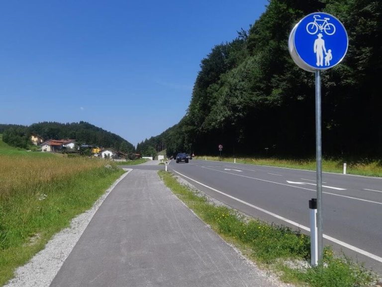 Neuer Geh- und Radweg entlang der L107 in Richtung Ebenau, mit Verkehrsschild für Radfahrer.