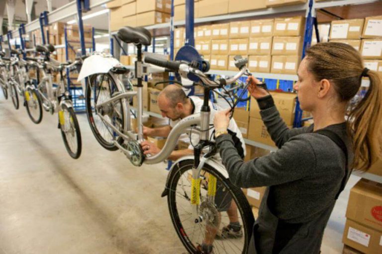 Fachkräfte montieren Fahrräder in Werkstatt, neue Lehrberufsperspektiven im Radbereich.