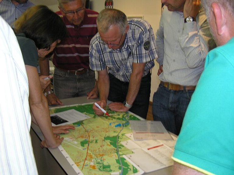Gruppendiskussion zur Fahrradplanung mit Karte und Markierungen in Salzburg.