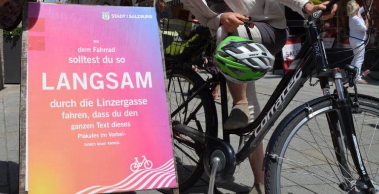 Plakat in der Linzergasse fordert langsames Radfahren in der Fußgängerzone.