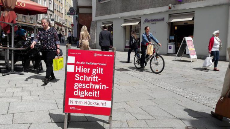 Plakat zur Schrittgeschwindigkeit für Radfahrer in der Fußgängerzone von Salzburg.