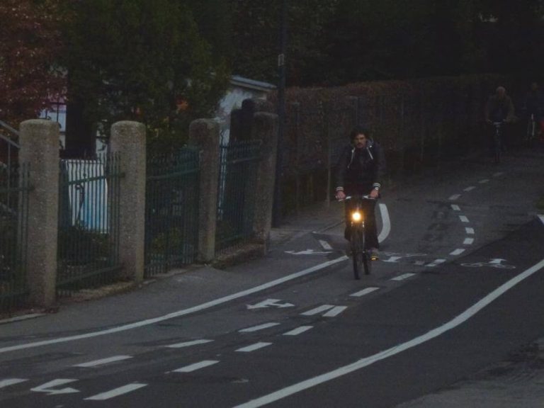 Radfahrer auf Fahrradstraße bei Dämmerung in Salzburg mit gut markierten Linien.