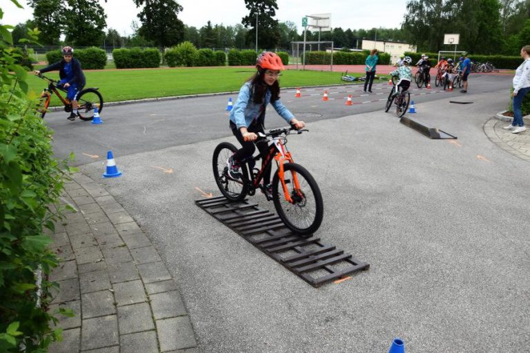 Kinder üben beim Fahrrad-Workshop Geschicklichkeit und Koordination mit Hindernissen.