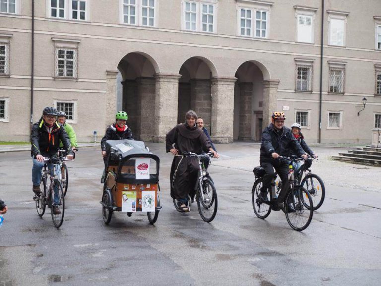 Mitarbeiter der Erzdiözese fahren mit Fahrrädern und Lastenrädern durch Salzburg.