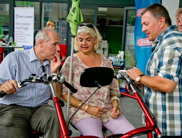 Drei Personen testen Spezialräder bei einer Schnupperaktion in Salzburg.