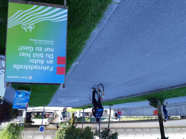 Fahrradfahrer auf einer Fahrradstraße mit Hinweis zur Verkehrssicherheit in Salzburg.