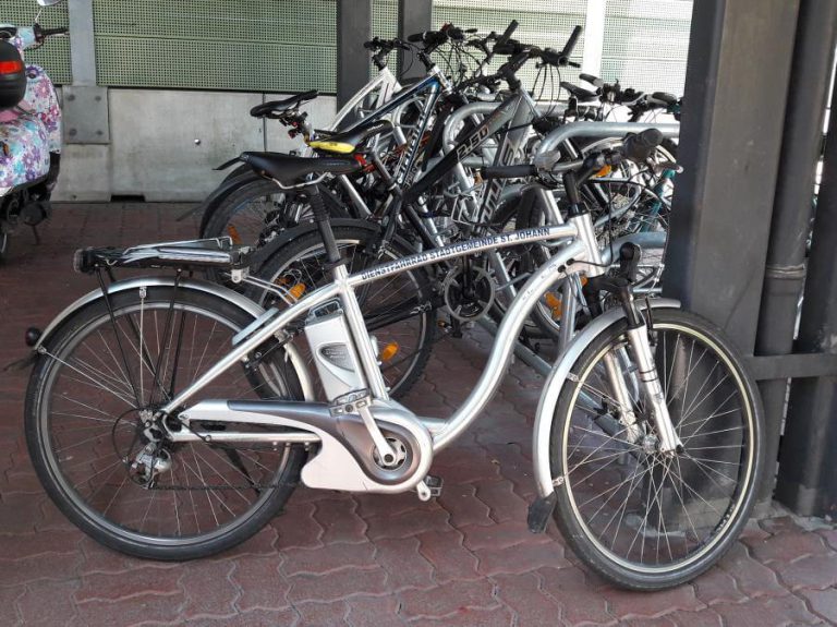 E-Bike mit "Dienstfahrrad"-Beschriftung zwischen anderen Fahrrädern.