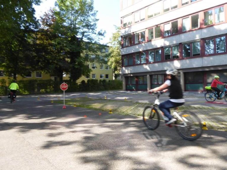Radfahrer:innen im E-Bike-Kurs üben auf einem Übungsgelände in Salzburg.