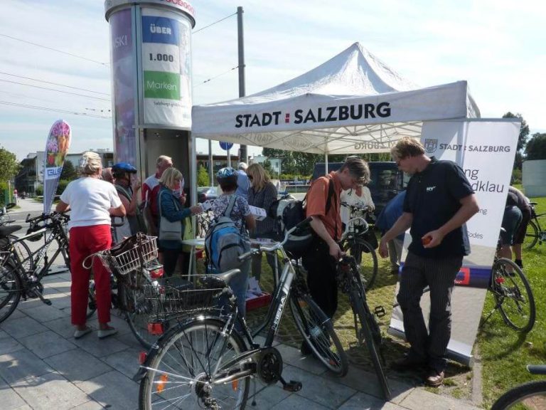 Fahrrad-Checks in Salzburg mit mehreren Radfahrern am Informationsstand der Stadt.