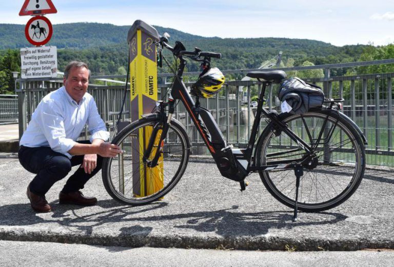 Mann überprüft Fahrrad an einer Radservicestation in Salzburg.