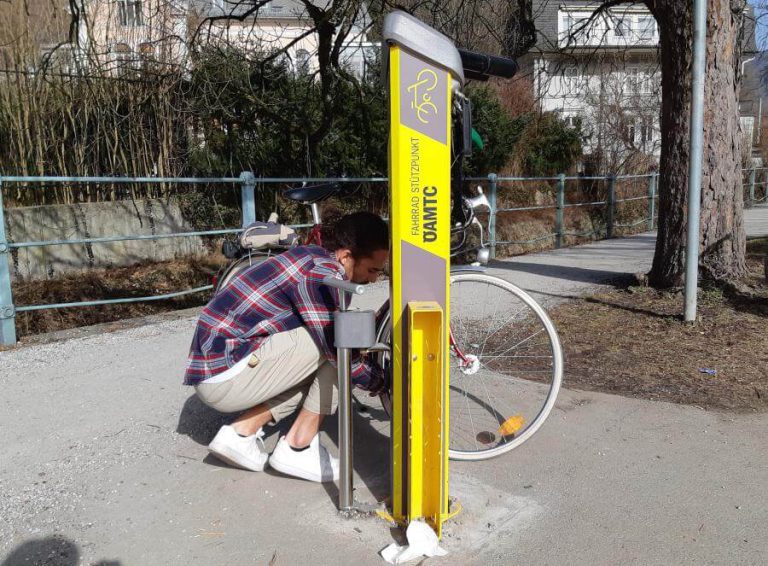 Fahrradfahrer arbeitet an einer Radservicestation im Freien.