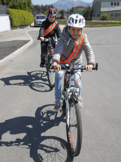 Kinder auf dem Fahrrad mit einer reflektierenden Schärpe