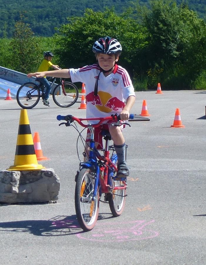 Kind auf dem Fahrrad gibt ein Handzeichen