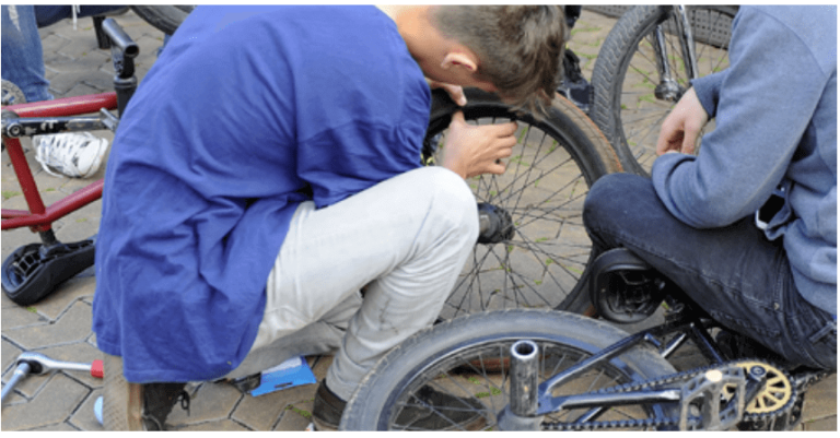 Jugendliche reparieren Fahrräder in einer Werkstatt zur Förderung von Mobilität und Klimaschutz.