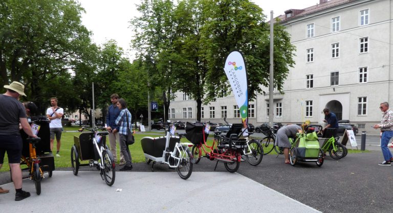 Menschen erkunden verschiedene Cargobikes auf der Mobilitätswoche in Salzburg.