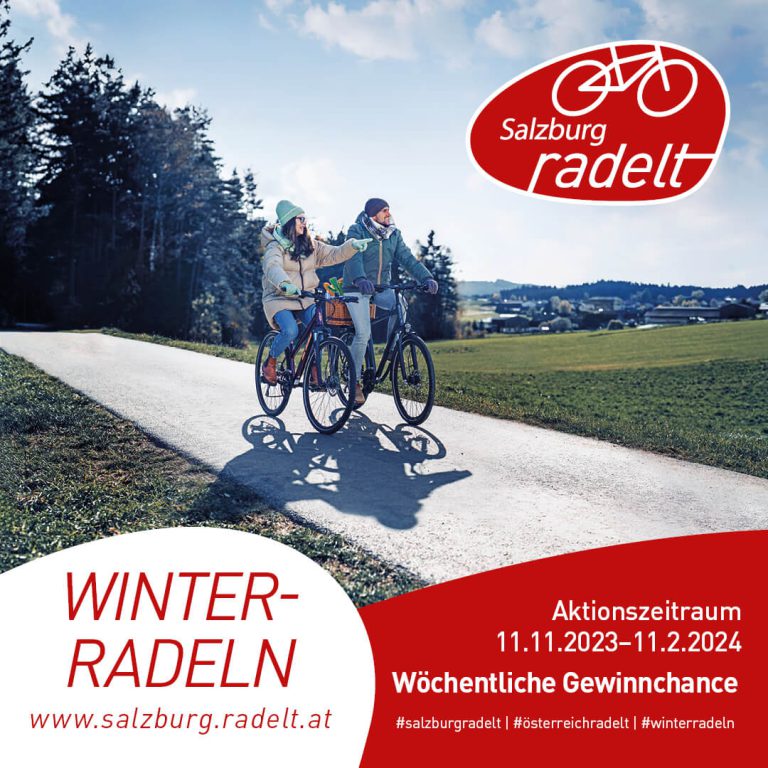 Zwei Radfahrer auf einem Weg vor bewaldeter Landschaft bei Winterradeln-Aktion in Salzburg.