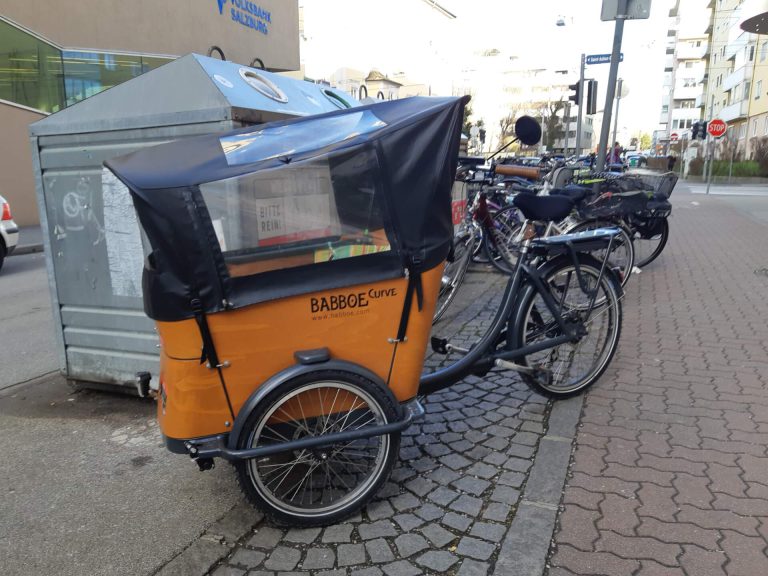 Lastenrad am Straßenrand in Salzburg, gefördert für nachhaltige Mobilität.