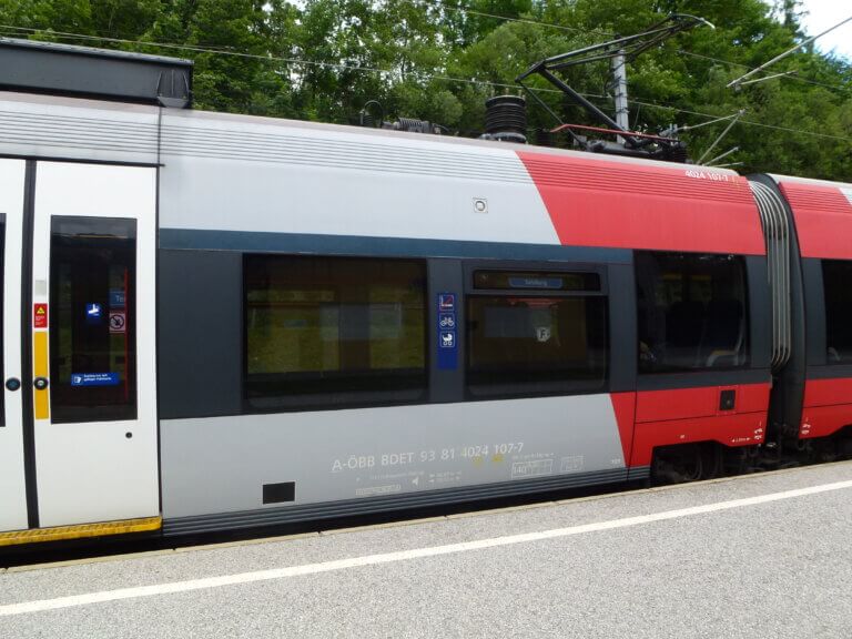 Zug mit Fahrradstellplatz am Bahnhof, ideal für nachhaltige Mobilität in Salzburg.