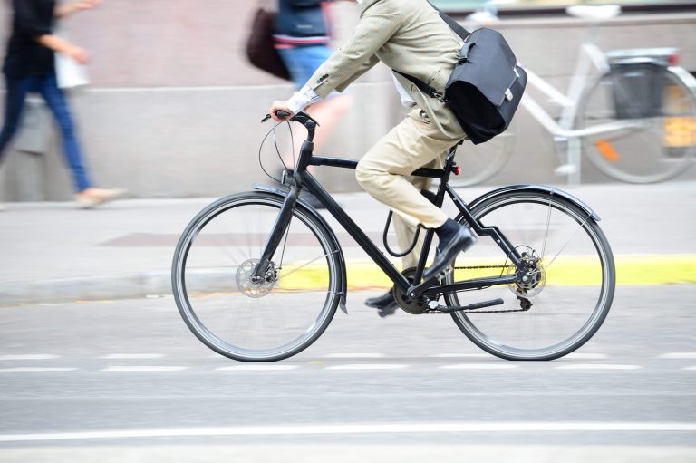 Fahrender Radfahrer auf urbaner Straße, Teil der Winterradeln-Aktion in Salzburg.